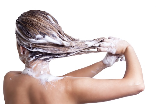 Mulher lavando o cabelo com caspas