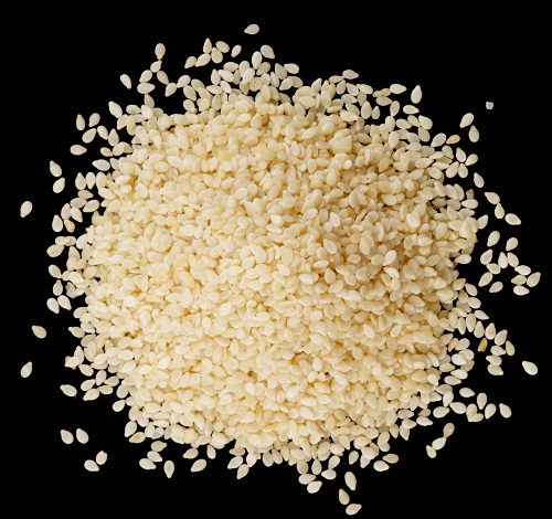 White sesame seeds on black surface