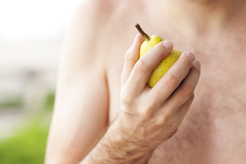 Homem segurando uma fruta para comer