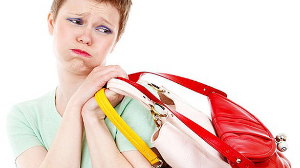 Mulher carregando bolsas pesadas. Isso pode prejudicar os ossos das mãos e dos braços.