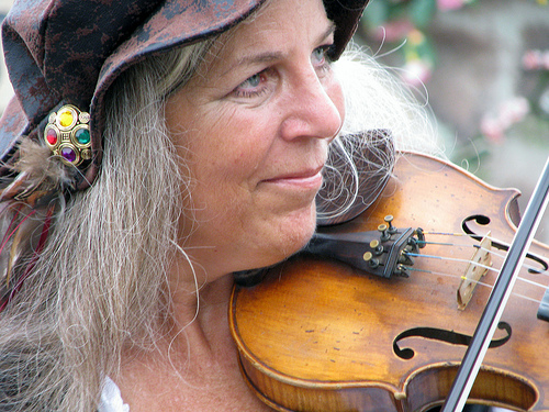 Mulher com fios brancos tocando violino