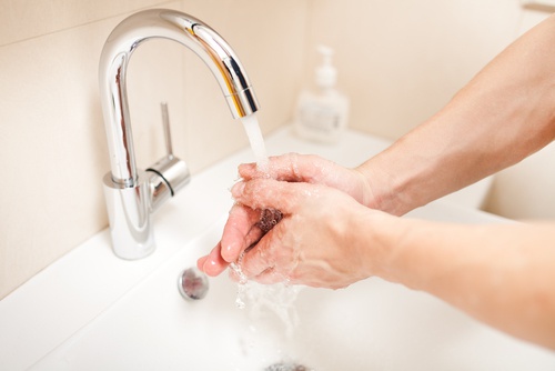 Pessoa lavando a pele das mãos