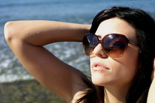 Mulher tomando sol com óculos