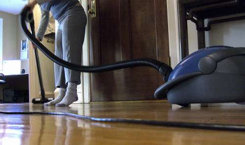 mulher limpando casa antiácaros