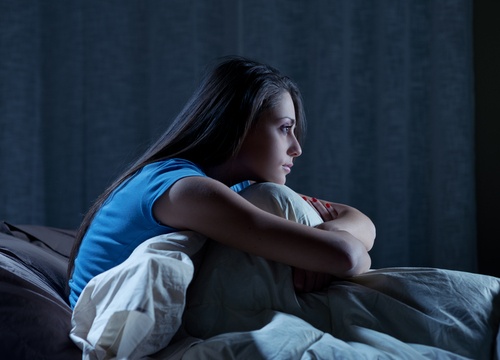 mulher com insônia pensando em como dormir