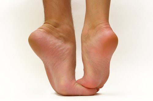 Pessoa alongando os pés para prevenir a fascite plantar