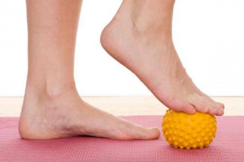 Pessoa fazendo exercício com uma bolinha para evitar a fascite plantar