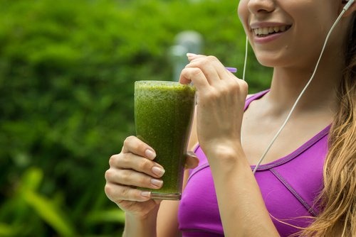 Mulher tomando vitamina verde para diminuir a hipertensão e limpar os rins