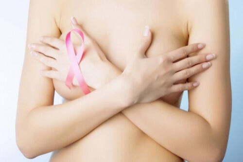 Mulher tampando os seios com símbolo do câncer de mama