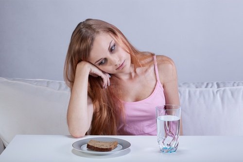 Mulher com falta de apetite por causa da tristeza
