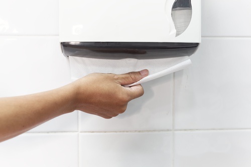 Mulher que usa banheiro público tirando papel
