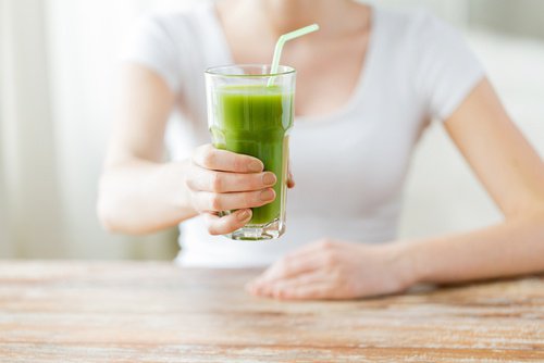 Mulher-segurando-copo-suco-verde