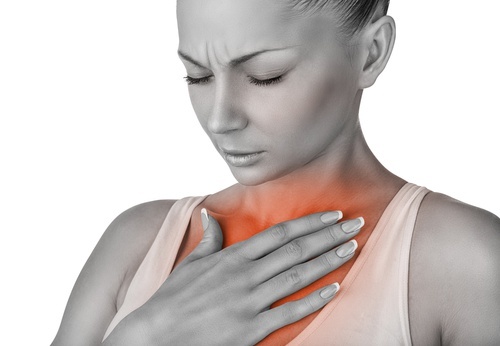 Mulher com dor no peito devido a doenças cardiacas