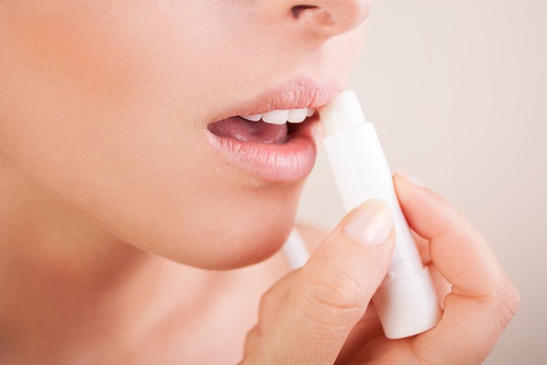 Mulher hidratando os labios com batom