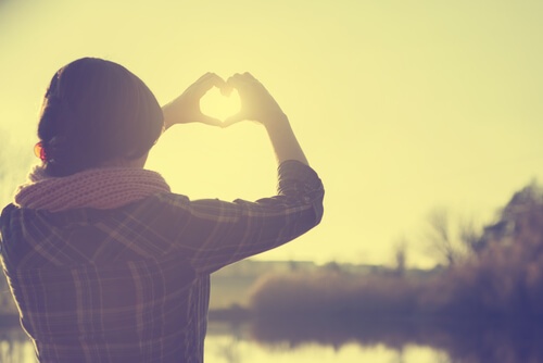 Mulher fazendo um coração com as mãos