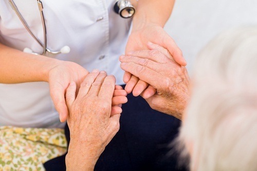 Médico revisando mãos com artrite