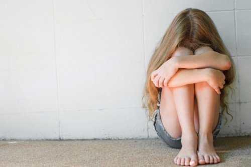 Menina triste pelo comportamento tóxico dos pais