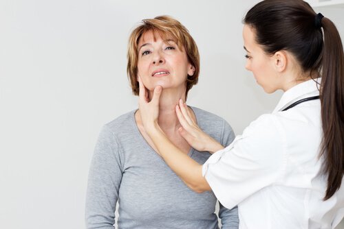 Médico examinando a tireoide de paciente