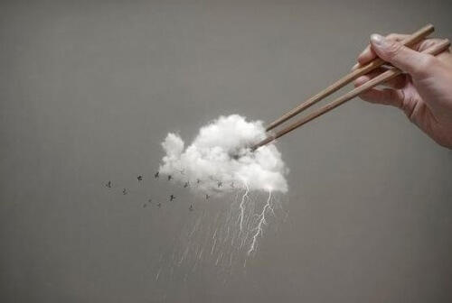 Pessoa rancorosa pegando uma nuvem com palitos