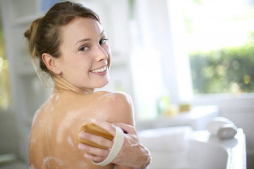 Mulher exfoliando as cosatas para evitar acne