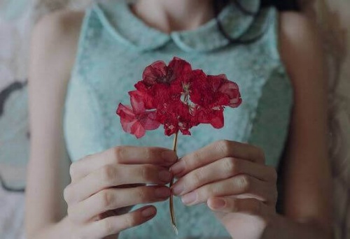 Mulher solteira segurando flor
