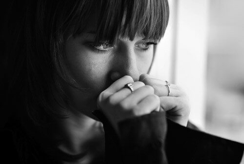 Moça com depressão olhando pela janela