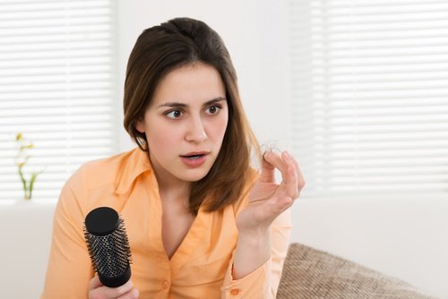Mulher com queda de cabelo devido a deficiência de vitamina C