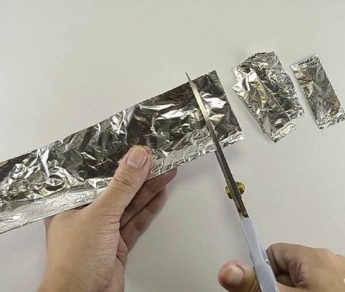 Mulher cortando papel alumínio