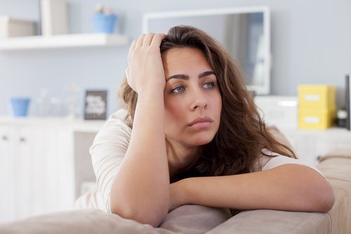 Mulher magoada pensando se deve iniciar um novo relacionamento
