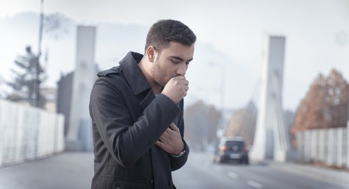Homem tossindo em um lugar frio
