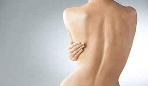 Mulher passando óleo de coco no corpo