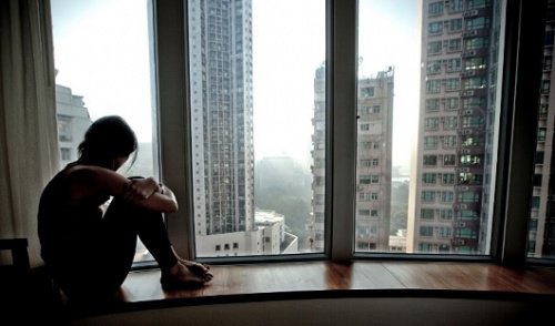 Mulher olhando pela janela e pensando com a mente