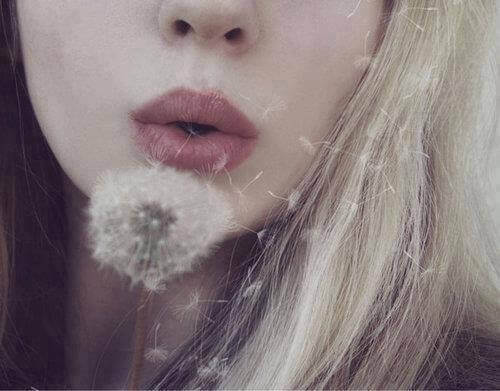 Boa pessoa soprando dente de leão