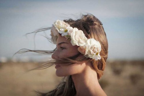 Mulher desfrutando do atual momento com flores na cabeça
