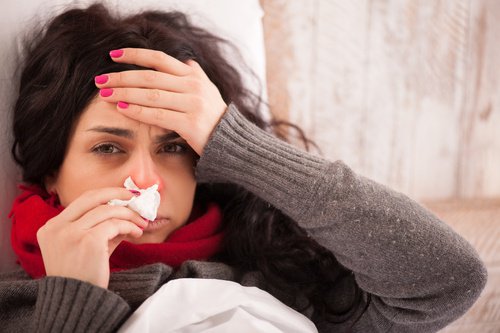 Mulher com gripe por causa do enfraquecimento do sistema imunológico