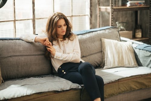 mulher_sentada_sofa_pensativa_cansada