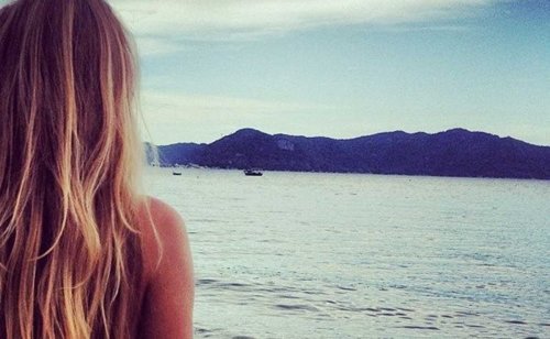 Moça olhando para os barcos que vão embora