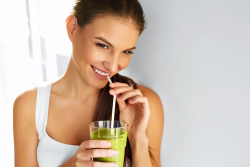 Mulher tomando suco para combater o envelhecimento precoce