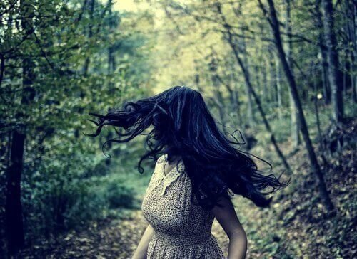 Mulher correndo com medo no bosque