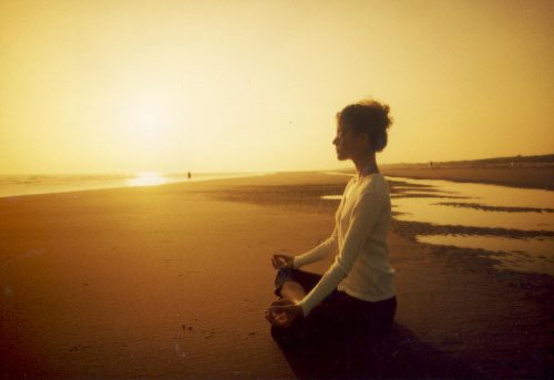Mulher meditando na praia