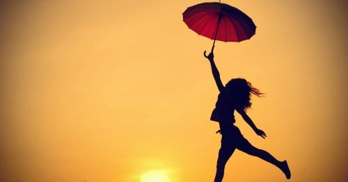 Mulher saltando segurando guarda-chuva