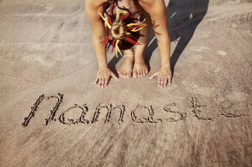 Palavra “Namastê” escrita na areia
