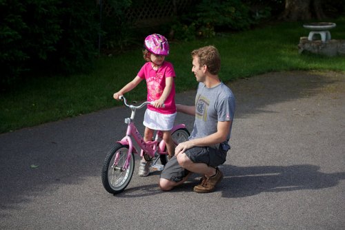 Pai e filha andando de bicicleta