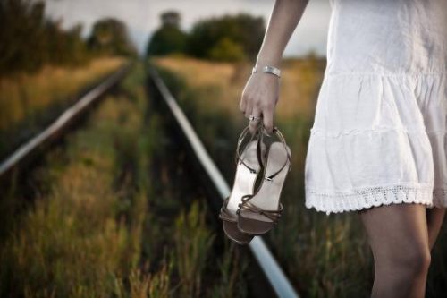 Mulher andando nas vias do trêm arriscando sua vida