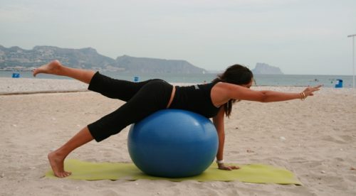 Mulher fazendo exercícios para os glúteos com uma bola