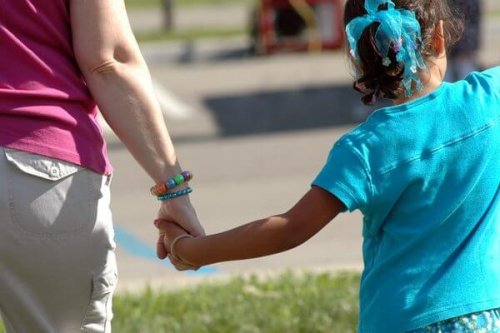 Mãe de mãos dadas com filha