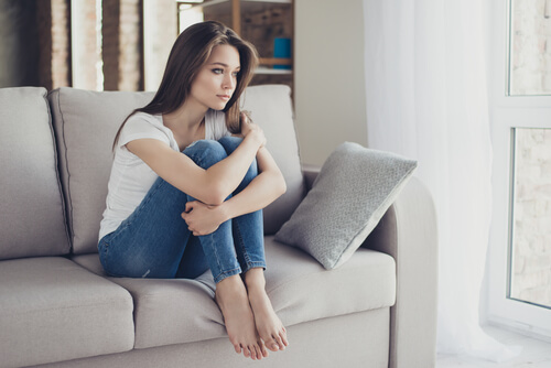Mulher triste sentada no sofá