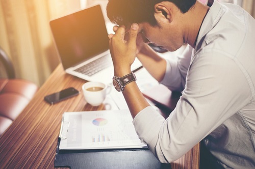 Homem sentindo dor de cabeça no trabalho