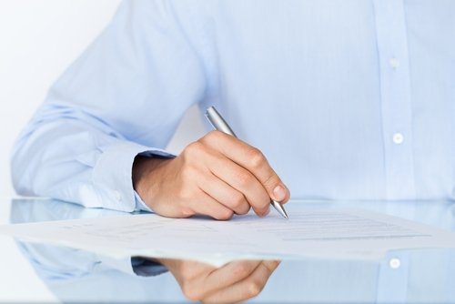 Homem assinando um documento