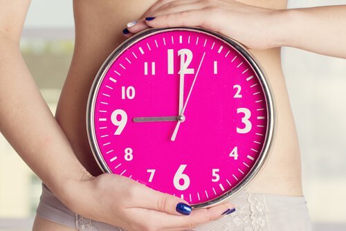 Mulher segurando relógio e controlando a amenorreia ou falta de menstruação